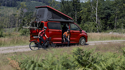 Két nő kerékpározásra készül a Ford Nugget körül